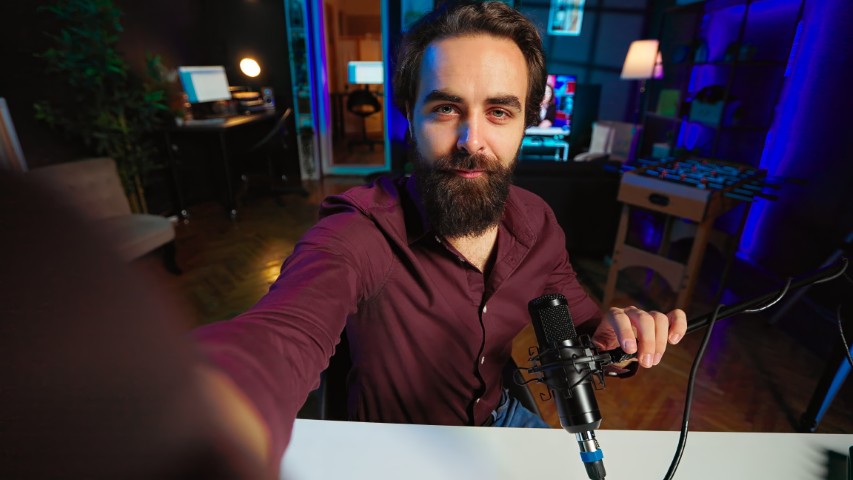 Creator adjusting the camera on a tripod before recording, with the teleprompter screen to be placed just below the lens